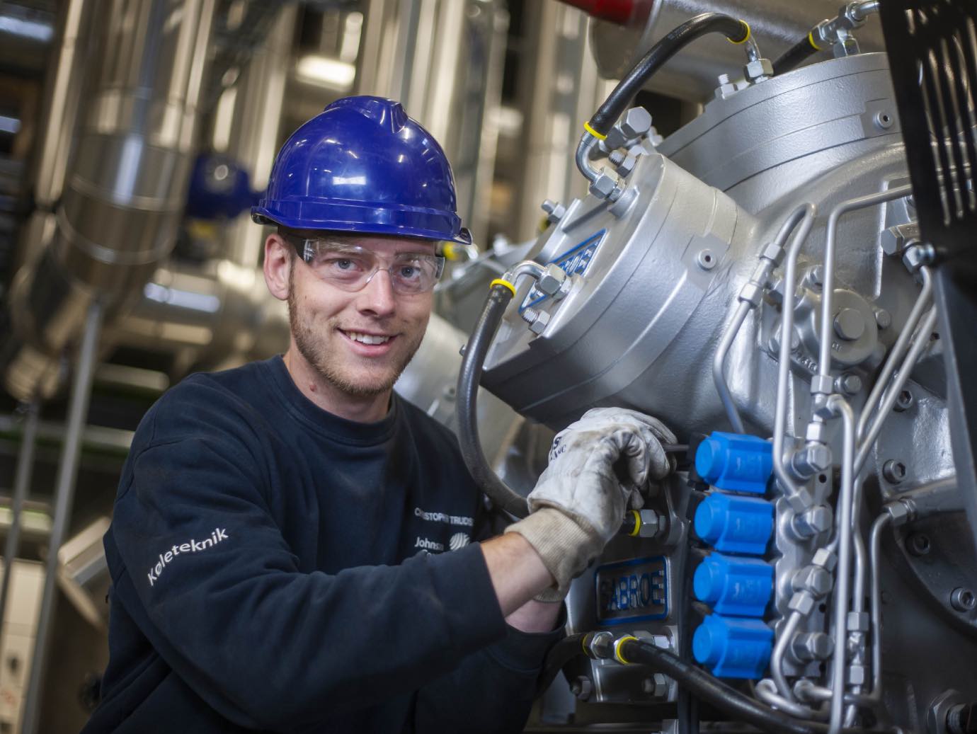 Man in safety equipment inspecting a machine